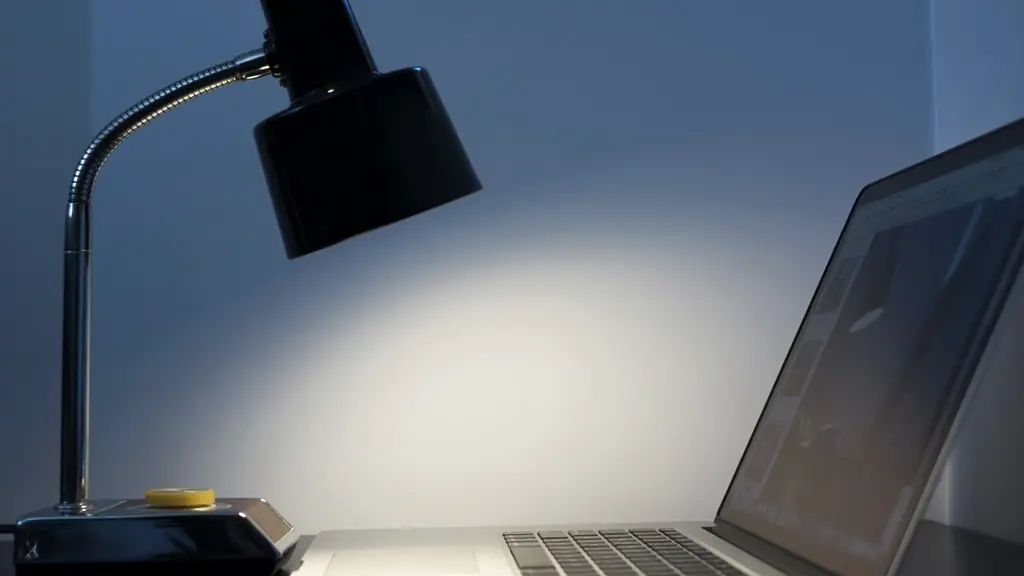 Lámpara de escritorio iluminando una notebook en un espacio de trabajo nocturno