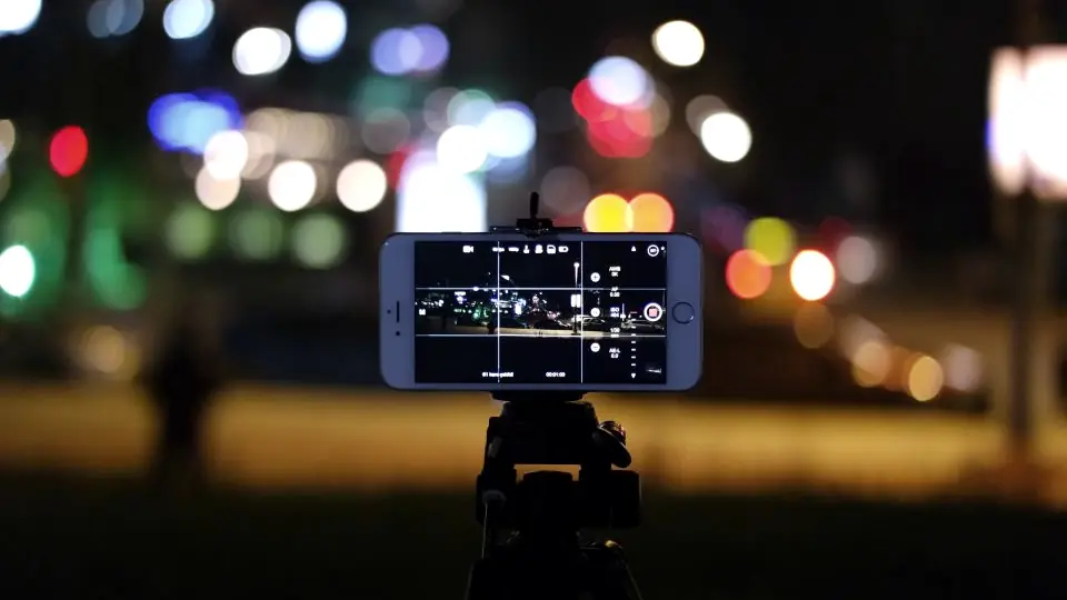 Celular sobre un trípode grabando de noche, la producción de contenido para redes