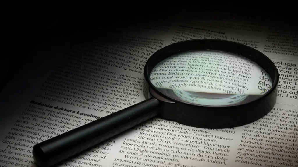 Lupa sobre una página impresa, la búsqueda de información